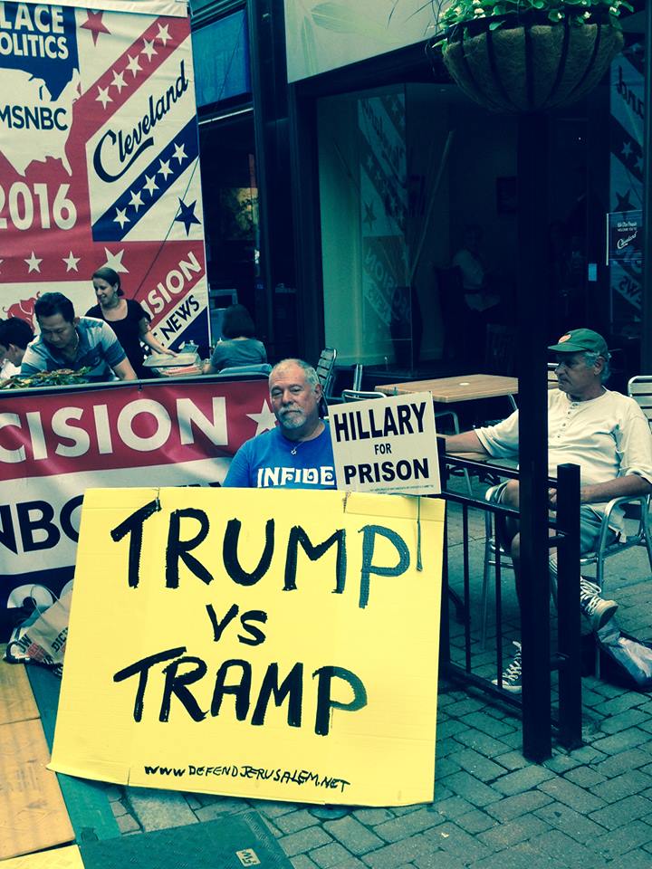 Надпись на плакатах: «Трамп против барабанного боя» и «Хиллари — в тюрьму», Кливленд, США, 19 июля 2016 года 